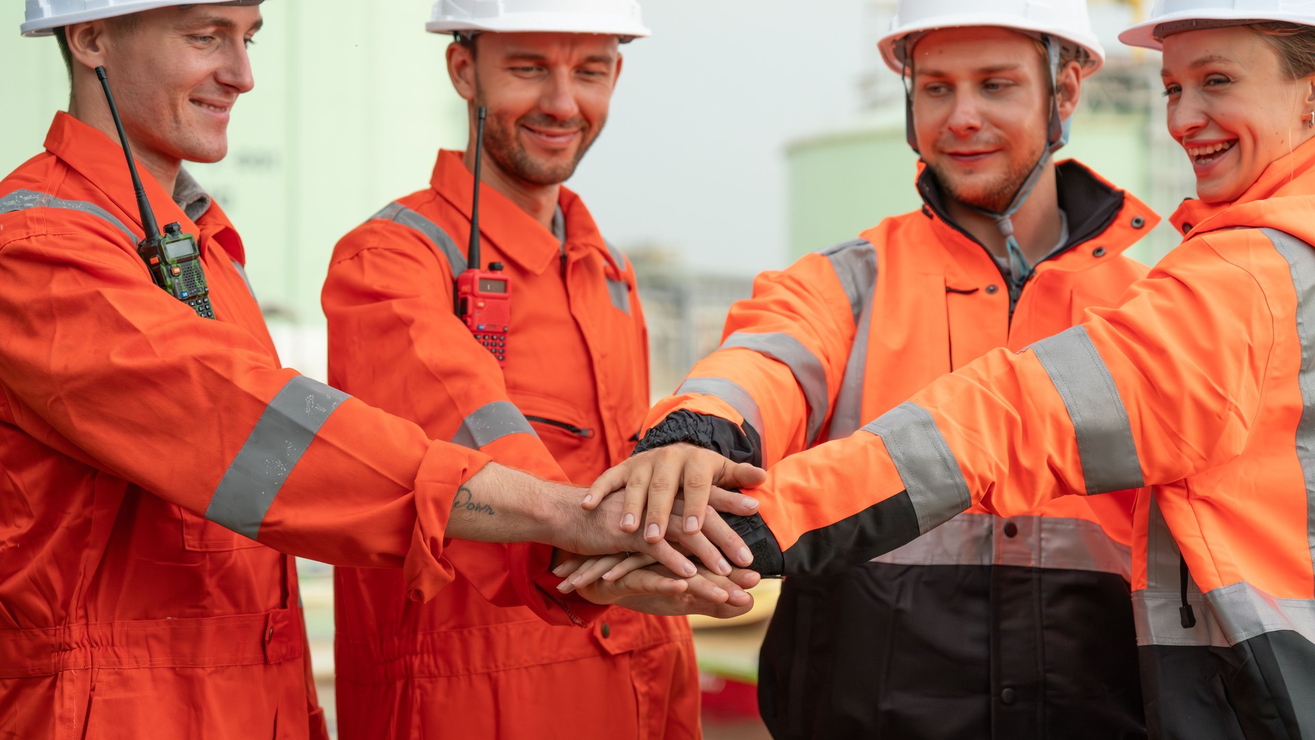 caucasian white engineers in safety uniforms and helmets using laptop and radio for site communication. Concept of teamwork, inspection, and operations at an industrial facility.Construction of Oil, Gas and Fuels Transport Pipeline,Pipe Manufacturing Fact